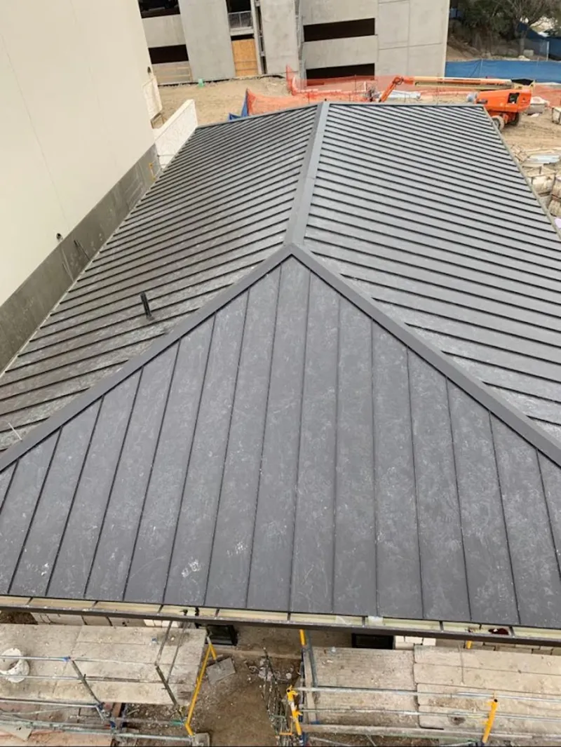 Commercial metal roof construction with crane equipment in Westwood